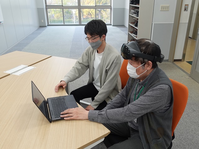 学生にVR環境について研究説明